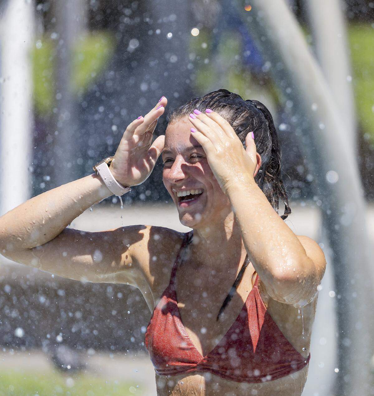Catarina Correia, 24, cools off in a splash pad in South Pointe Park as hot weather moves through the area on Friday, Aug. 15, 2025, in Miami Beach, Fla. Forecasters have issued heat advisories throughout the summer in South Florida, with temperatures at times feeling as hot as 109 degrees.