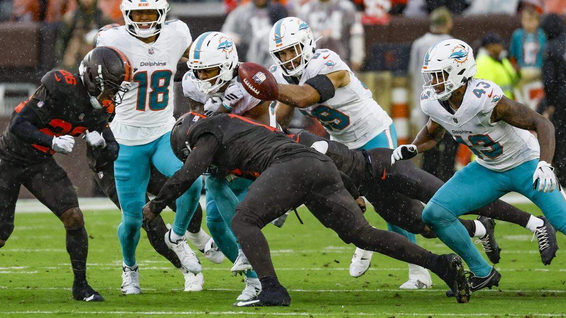 Miami Dolphins wide receiver Dee Eskridge (82) fumbles the ball after getting hit by Cleveland Browns outside linebacker Jerome Baker (17) during the first half of an NFL football game at Huntington Bank Field in Cleveland, Ohio, on Sunday, October 19, 2025.