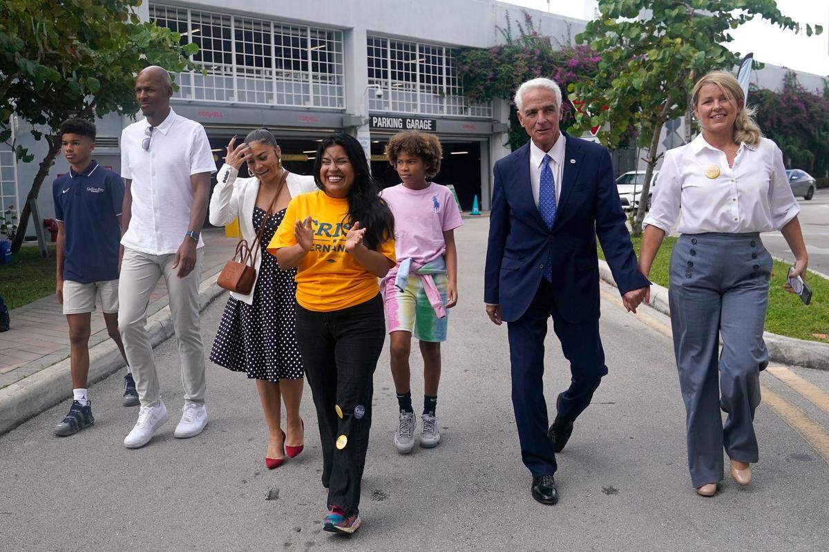 Democratic candidate for Florida governor Charlie Crist, second from right, arrives with his fiancee Chelsea Grimes, right, and his running mate Karla Hernandez-Mats, center, as he campaigns at an early voting location, Sunday, Nov. 6, 2022, in Miami. Second from left is former Miami Heat player Ray Allen.