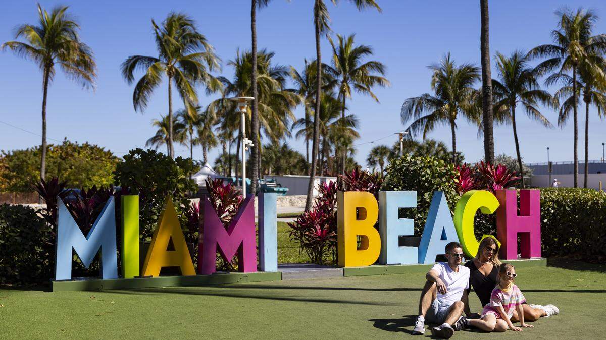 People gather for a photo at Lummus Park near Ocean Drive on Tuesday, Feb. 24, 2026, in Miami Beach, Florida.