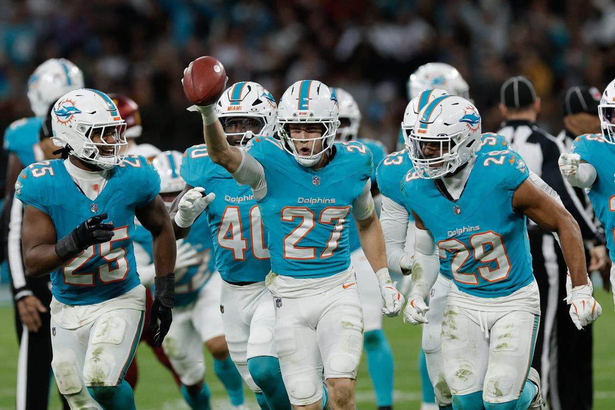 Miami Dolphins' cornerback #27 Ethan Bonner (C) and teammates celebrate recovering possession after a kickoff during the fourth quarter of their NFL match between Miami Dolphins and Washington Commanders at Santiago Bernabeu Stadium in Madrid on November 16, 2025. (Photo by Oscar DEL POZO / AFP) (Photo by OSCAR DEL POZO/AFP via Getty Images)