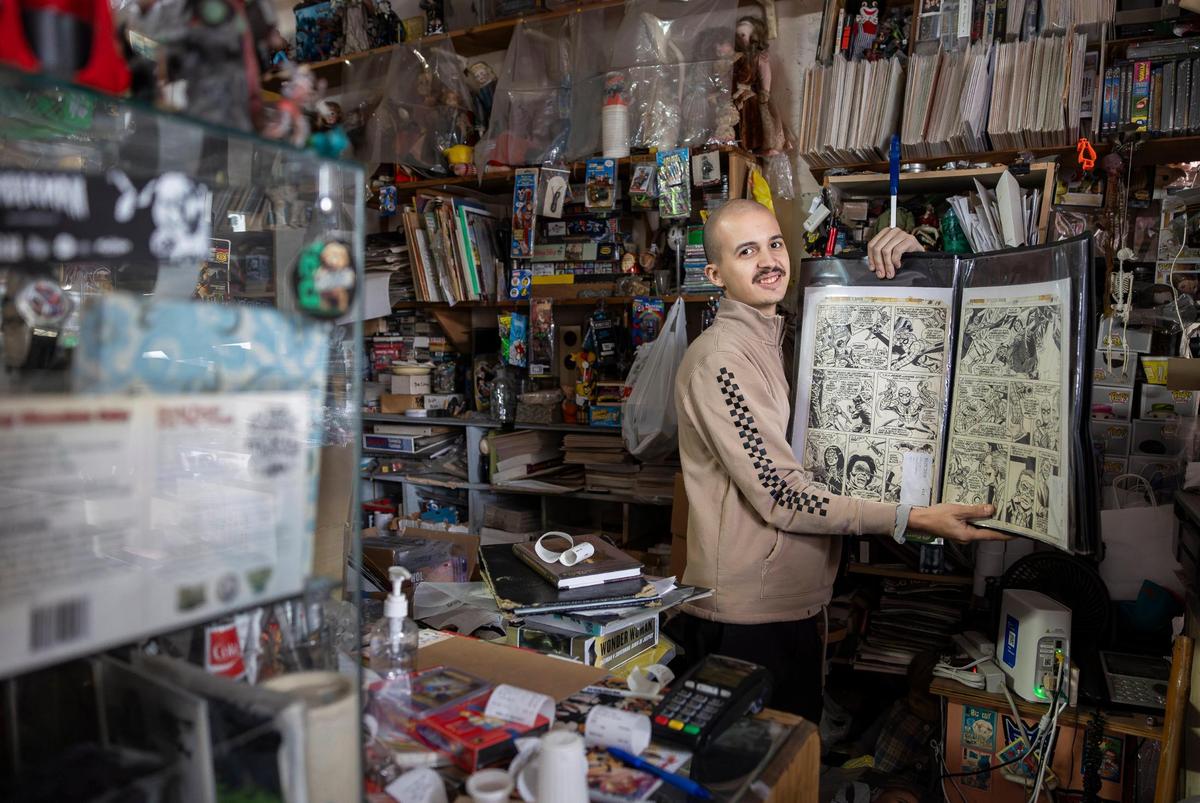 Ruben Arenas, 25, the store manager, holds two pages of original art by Ross Andru, pages 14 and 15 of The Amazing Spider-Man issue 184, that are up for sale at A&M Comics and Books on Friday, Jan. 24, 2025, in Miami.