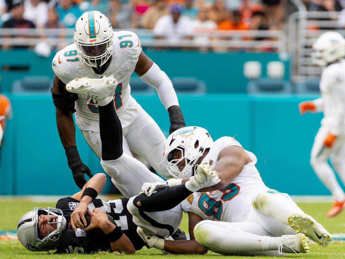 Las Vegas Raiders quarterback Gardner Minshew (15) is being sacked by Miami Dolphins defensive tackle Calais Campbell (93) in the second half of their NFL game at Hard Rock Stadium on Sunday, Nov. 17, 2024, in Miami Gardens, Fla