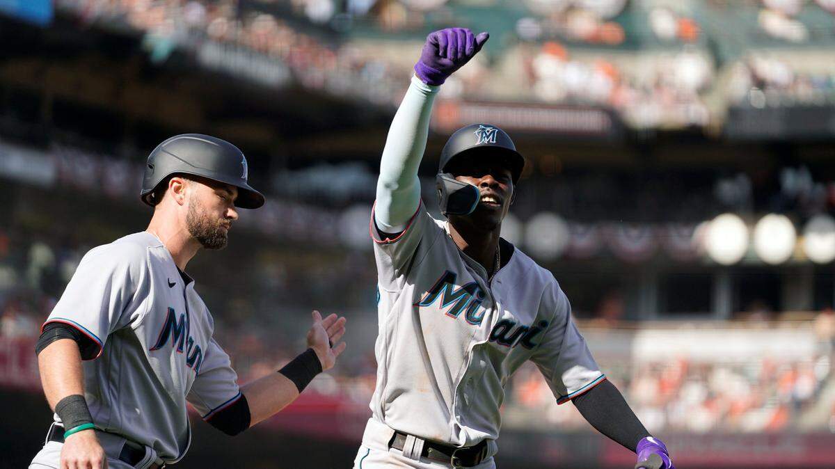 Miami Marlins’ Jazz Chisholm Jr., is greeted at home plate by Jon Berti, left, after hitting a two-run home run off San Francisco Giants relief pitcher Camilo Doval in the ninth inning inning of a baseball game Friday, April 8, 2022, in San Francisco. (AP Photo/Eric Risberg)