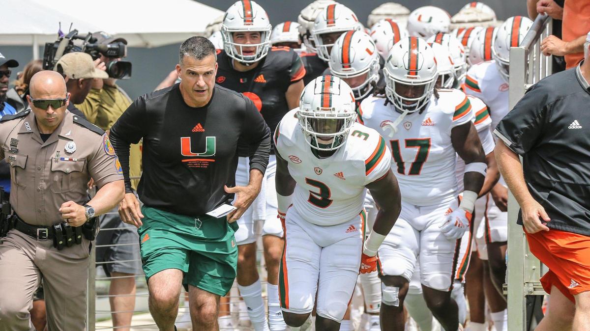 Miami Hurricanes head coach Mario Cristobal and the team run onto the field for the start of the University of Miami spring game at DRV PNK Stadium in Fort Lauderdale, Florida on Saturday, April 16, 2022.