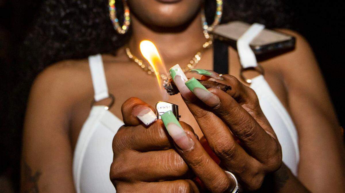 A woman lights a marijuana blunt on Ocean Drive during the fourth week of Spring Break in Miami Beach, Florida, on Saturday, March 25, 2023. In November 2024, Florida voters will decide whether to legalize the use of recreational marijuana. But will you be able to smoke it anywhere?
