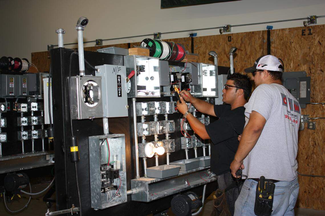 An Associated Builders and Contractors Institute instructor works with a student on trouble shooting circuits in the organization’s electrical training lab.