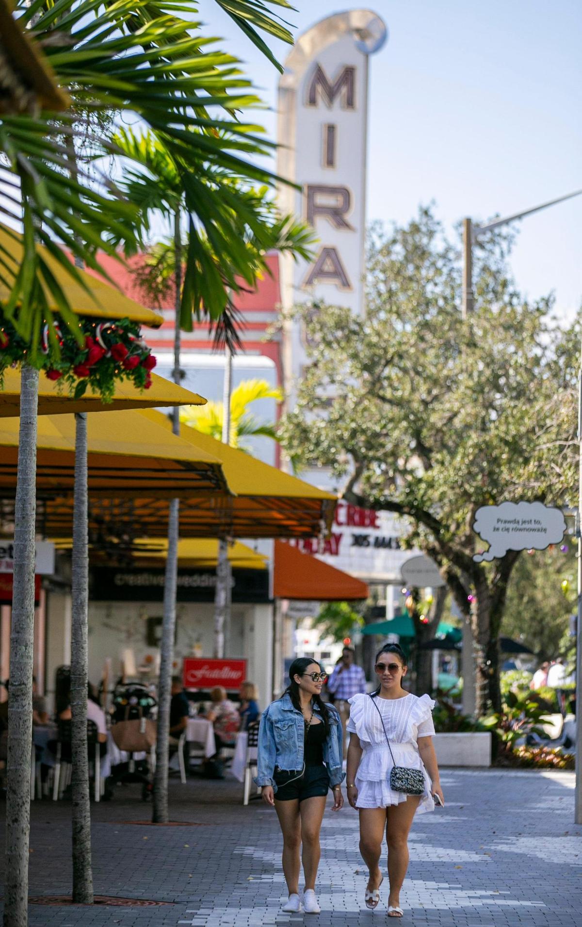 Nineteen tenants are opening along Miracle Mile in 2022. Samira Gurrola, left, and Sandra Dunlap, make their way down Miracle Mile in Coral Gables, Florida on Friday, Dec. 10, 2021.