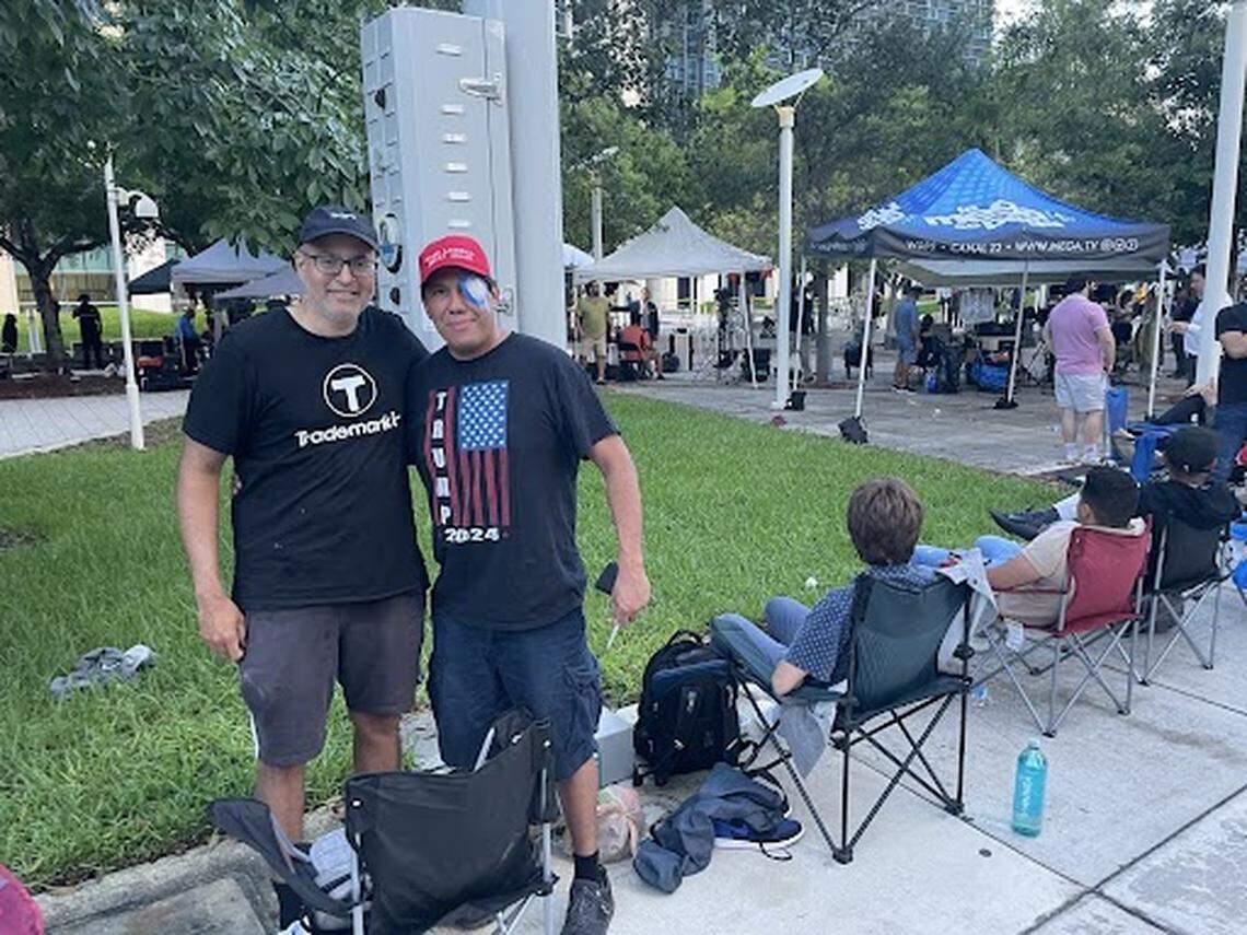 As the sun rose Tuesday, Raj Abhyanker, left, and Lazaro Encenarro hold their spots in line for the Trump court hearing outside the federal courthouse.