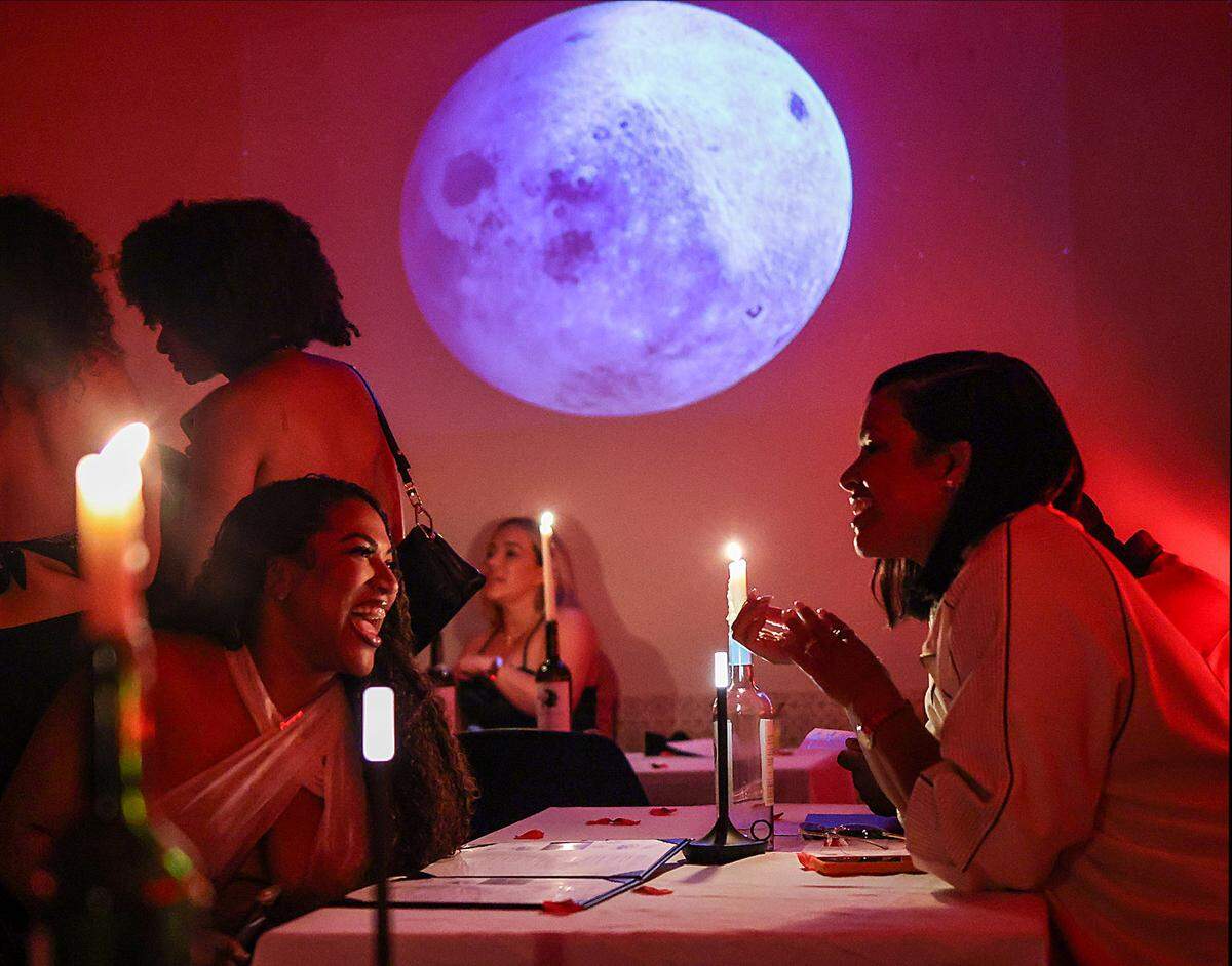 Guests engage in conversation under red velvet lighting at Love Language’s event on Sunday, April 5, 2026, in Miami, Florida. Kyle Hoto Reid, founder of the Love Languages event, hosts a party focused on intimacy and low-key aesthetics at Bargean in Little Havana, Miami, Florida on Sunday, April 5, 2026.