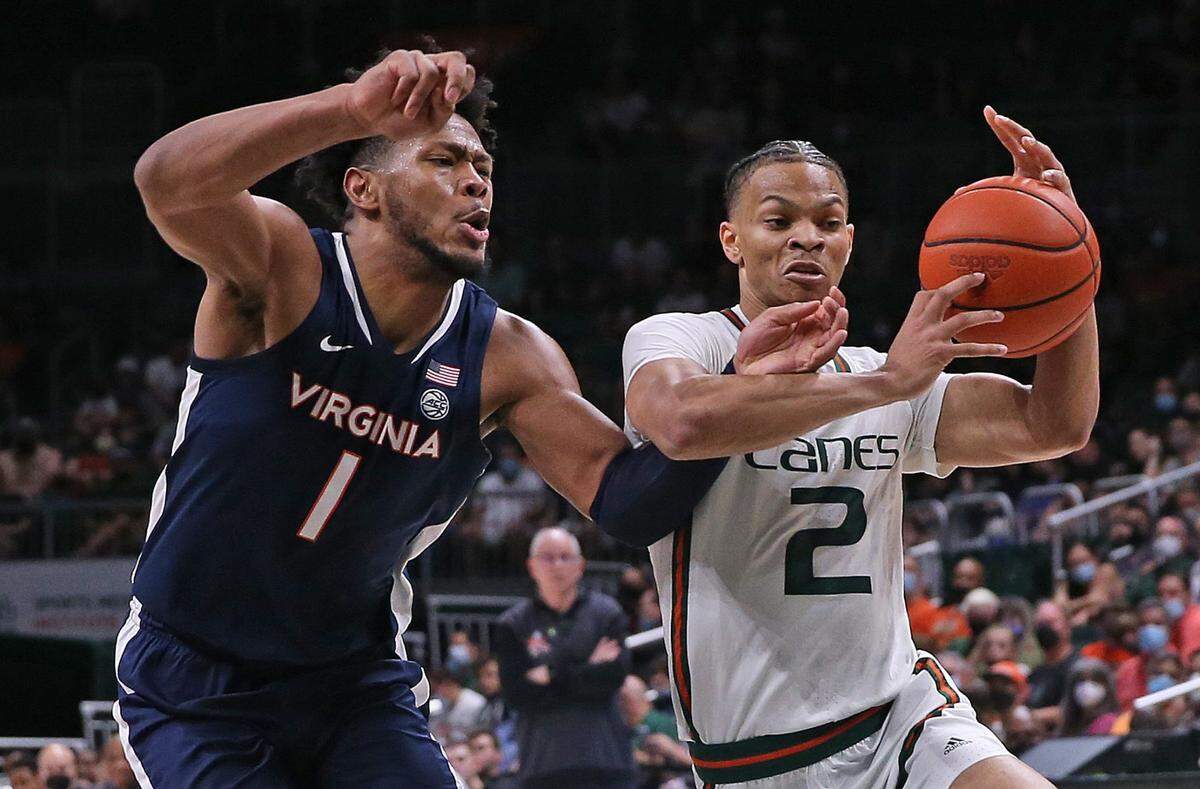 Miami Hurricanes guard Isaiah Wong (2) battles Virginia Cavaliers forward Jayden Gardner (1) in the first half at the Watsco Center in Coral Gables on Saturday, February 19, 2022.