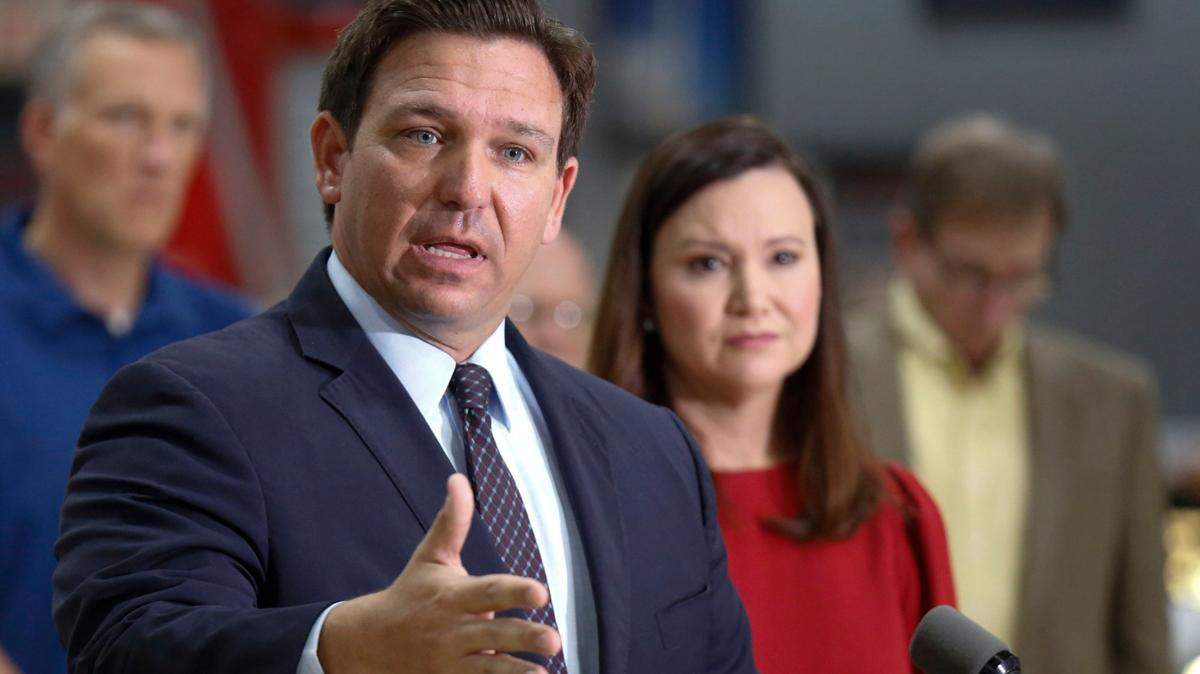 Florida Gov. Ron DeSantis, flanked by Attorney General Ashley Moody and supporters, addresses the media and supporters on Oct. 28, 2021, in Lakeland.