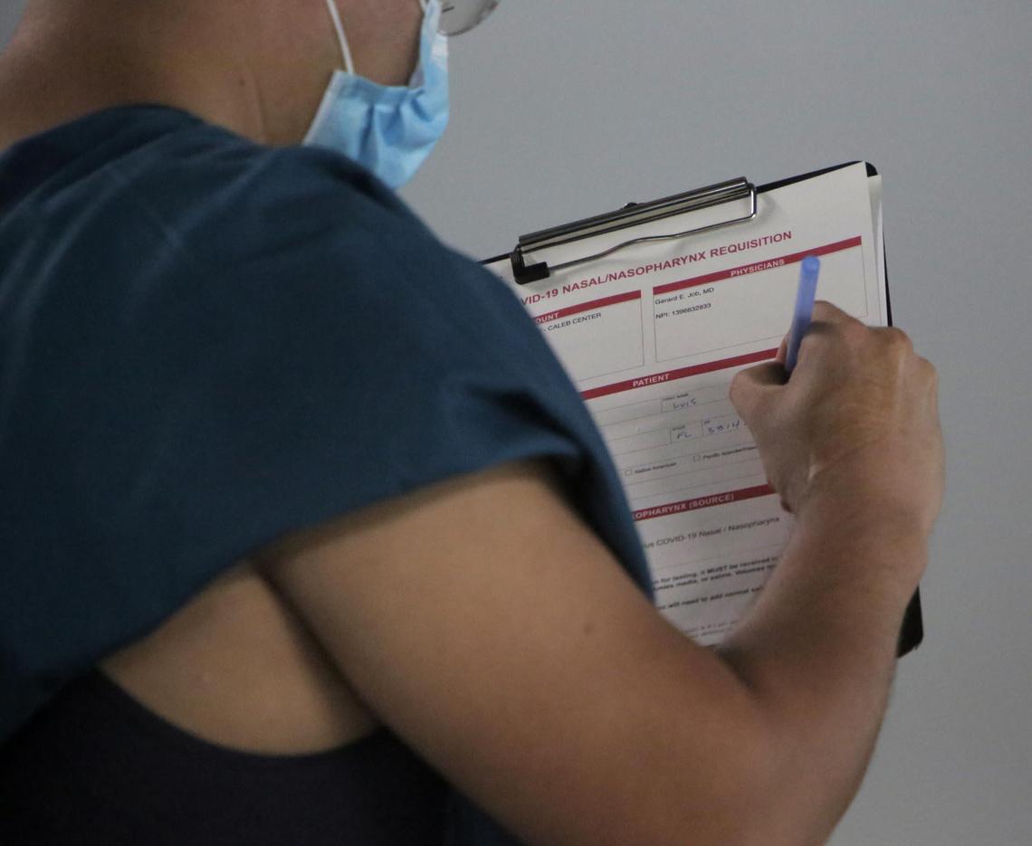 A man fills out a form at the Caleb Center garage as he waits to get tested for COVID-19.