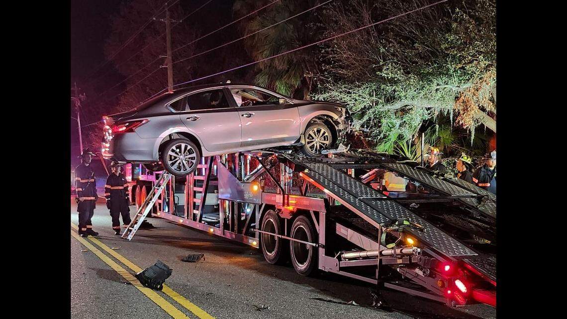 Man who drove onto parked truck trailer had to be rescued when vehicle got stuck dangling in the air, Florida rescuers say.