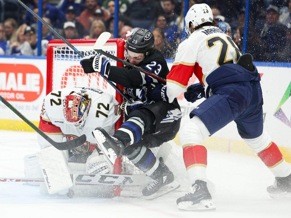 Feb 17, 2024; Tampa, Florida, USA; Tampa Bay Lightning center Michael Eyssimont (23) is forced into the goal by Florida Panthers defenseman Josh Mahura (28) in the first period at Amalie Arena.