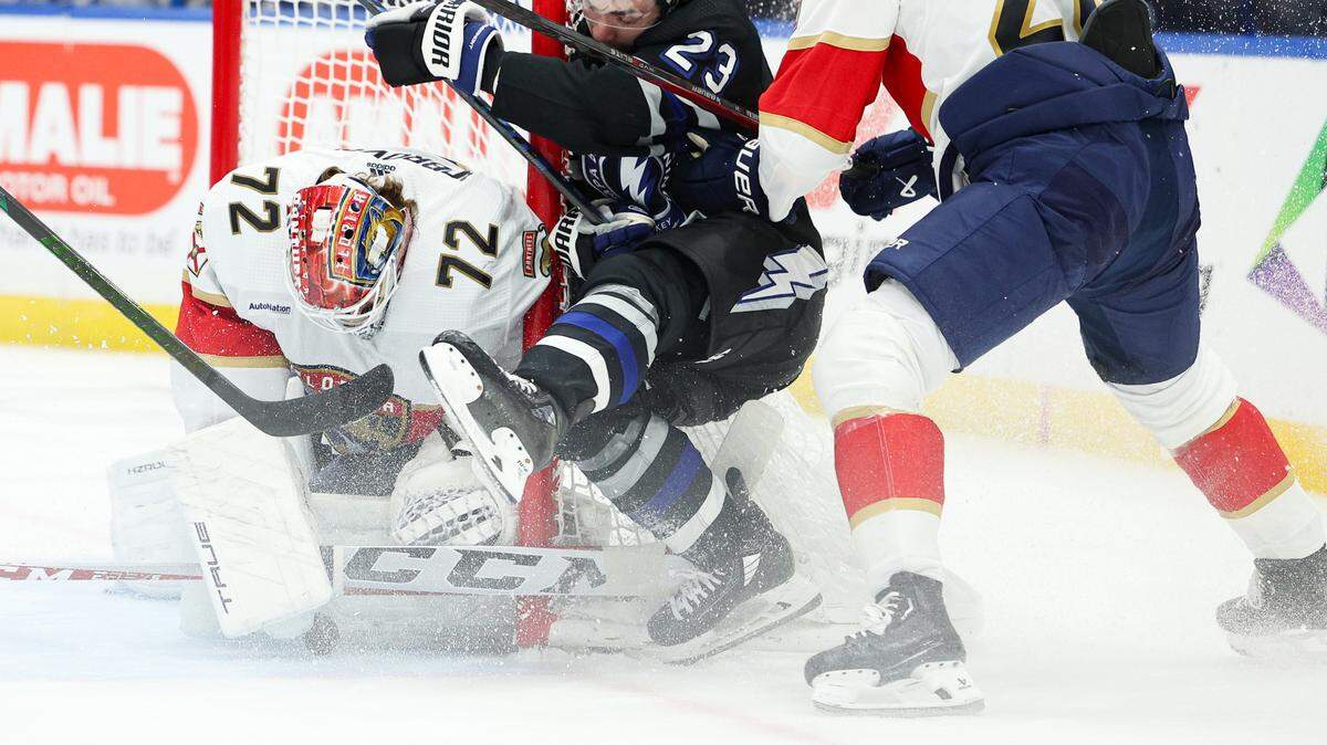 Feb 17, 2024; Tampa, Florida, USA; Tampa Bay Lightning center Michael Eyssimont (23) is forced into the goal by Florida Panthers defenseman Josh Mahura (28) in the first period at Amalie Arena.