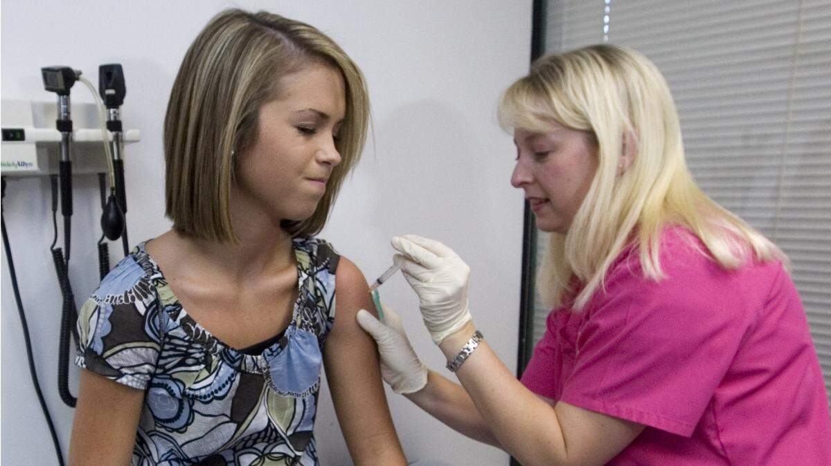 FILE - In this Tuesday, Dec. 18, 2007 file photo, Lauren Fant, left, winces as she has her third and final application of the Human Papillomavirus (HPV) vaccine administered by nurse Stephanie Pearson at a doctor’s office in Marietta, Ga.