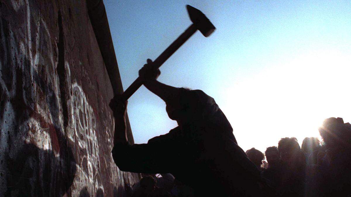 In 1989, a man hammers at the Berlin Wall as the border barrier between East and West Germany was torn down after 28 years.