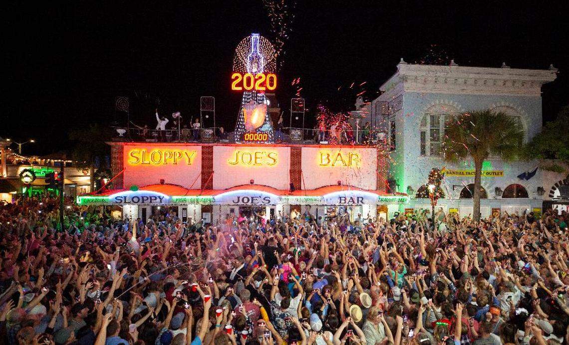 New Year’s Eve revelers celebrate outside Sloppy Joe’s Bar Wednesday, Jan. 1, 2020, after a facsimile of a conch shell was lowered to the roof of the bar.