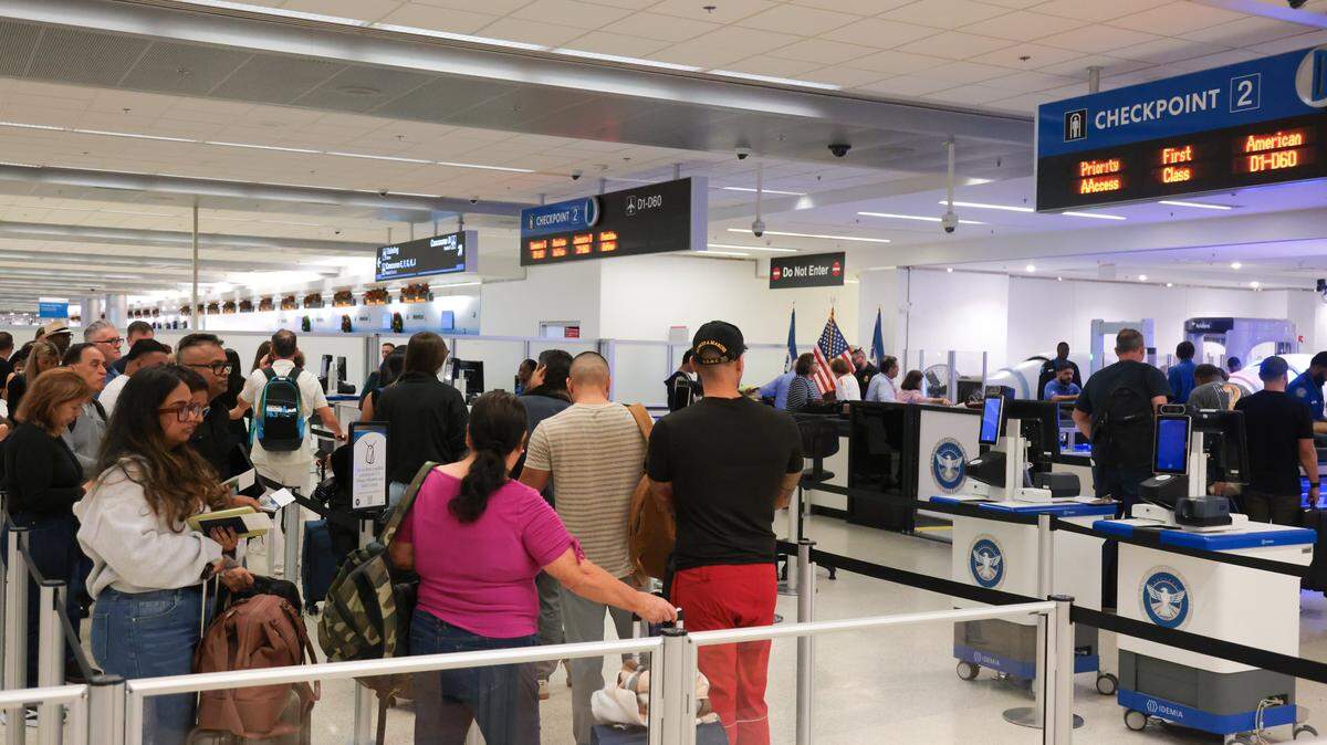 Travelers wait in line before going through security at TSA checkpoint 2 at Miami International Airport on Tuesday, Nov. 25, in Miami, Fla.