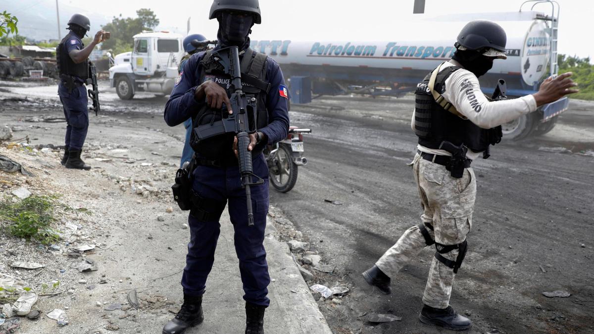 Police officers direct traffic to facilitate the passage of fuel trucks in Port-au-Prince, Haiti, Tuesday, Nov. 8, 2022. Trucks lined up at the fuel terminal to fill up their tanks for the first time since a powerful gang seized control of the area nearly two months earlier.