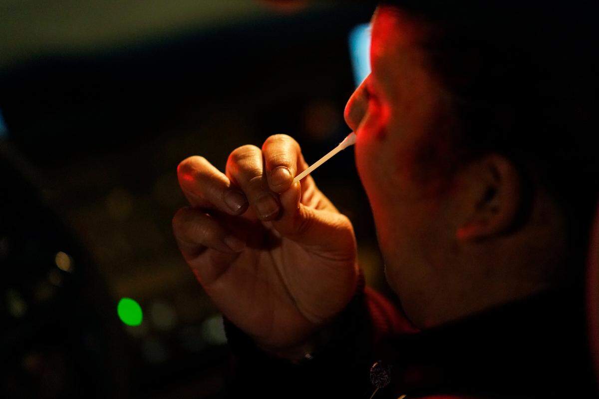 In this stock photo, a person self administers a COVID-19 test at a drive-thru testing site Wednesday, Jan. 19, 2022, in Las Vegas.