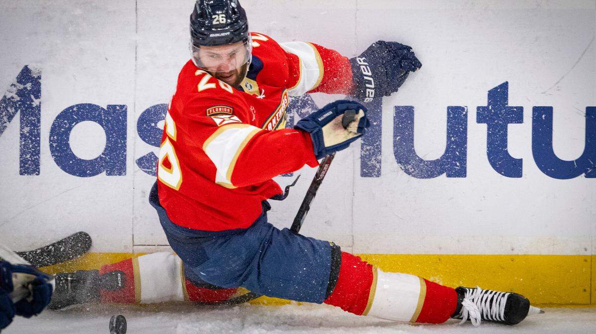 Florida Panthers defenseman Uvis Balinskis (26) falls while taking a shot around Carolina Hurricanes center Sebastian Aho (20) in the first period of Game 4 during the Eastern Conference final of the NHL Stanley Cup playoffs at the Amerant Bank Arena on Monday, May 26, 2025 in Sunrise, Fla.
