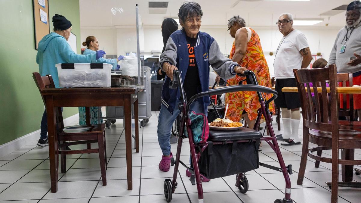Romelia Canales, 81, a resident at Mia Casa, receives a plate of food on Thursday, Jan. 16, 2025, in North Miami, Florida. Mia Casa, owned by Miami-Dade County’s Homeless Trust, supports 120 homeless seniors aged 65 and older with shelter and assistance transitioning to permanent housing.