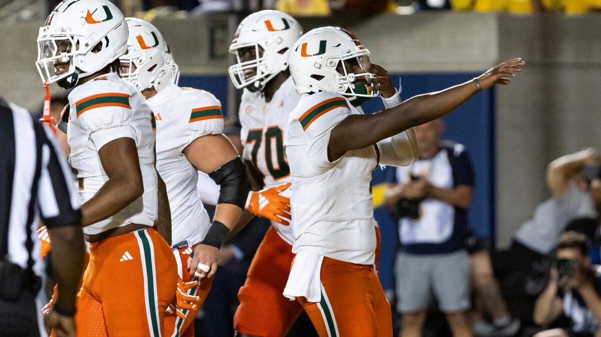 Miami Hurricanes quarterback Cam Ward (1) reacts after tight end Elijah Arroyo (8) scored a touchdown against the California Golden Bears in the second half of their NCAA college football game at the California Memorial Stadium on Saturday, Oct. 5, 2024, in Berkeley, Calif.