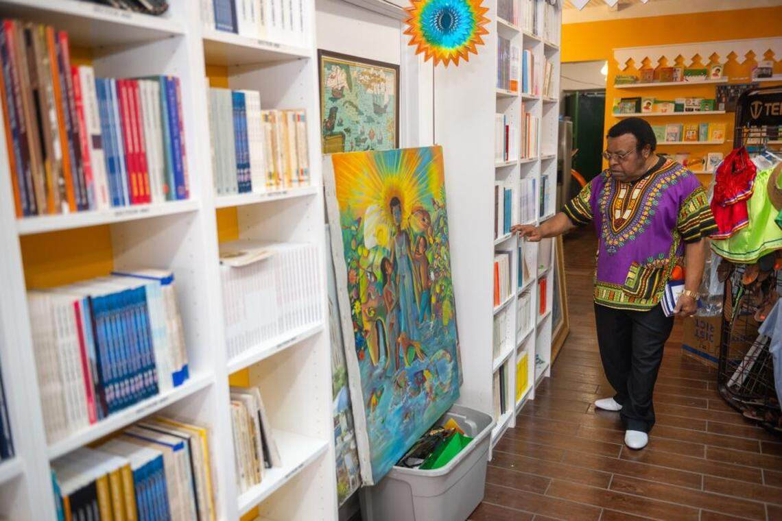 A festivalgoer browses books amid artworks at Libreri Mapou, Jean Mapou’s bookstore located next to the Caribbean Marketplace. 