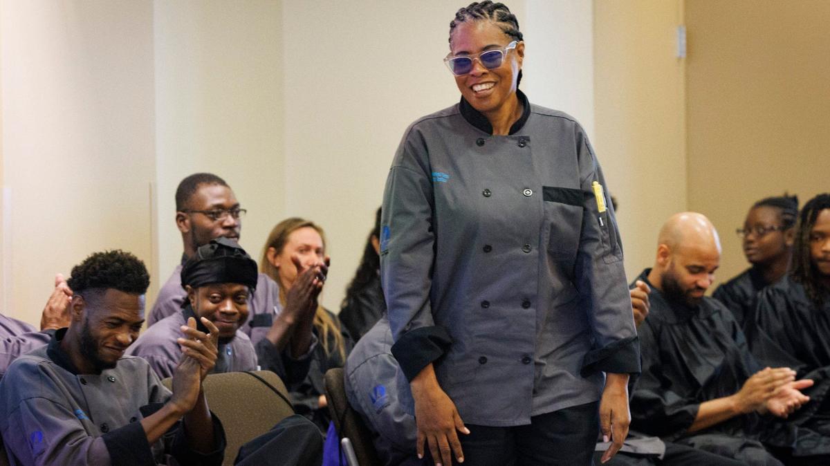 Angela Banks, center, gets cheered on by fellow classmates as her name is called to speak during their graduation ceremony for the Kitchen Cook and Hotel Property Specialist programs on Wednesday, Sept. 11, 2024, at Camillus House in Miami.