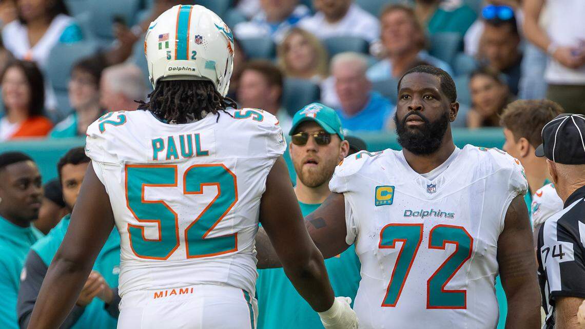 Miami Dolphins offensive tackle Terron Armstead (72) high five teammate Patrick Paul (52) after a play in the second half of their NFL game against the New England Patriots at Hard Rock Stadium on Sunday, Nov. 24, 2024, in Miami Gardens, Fla