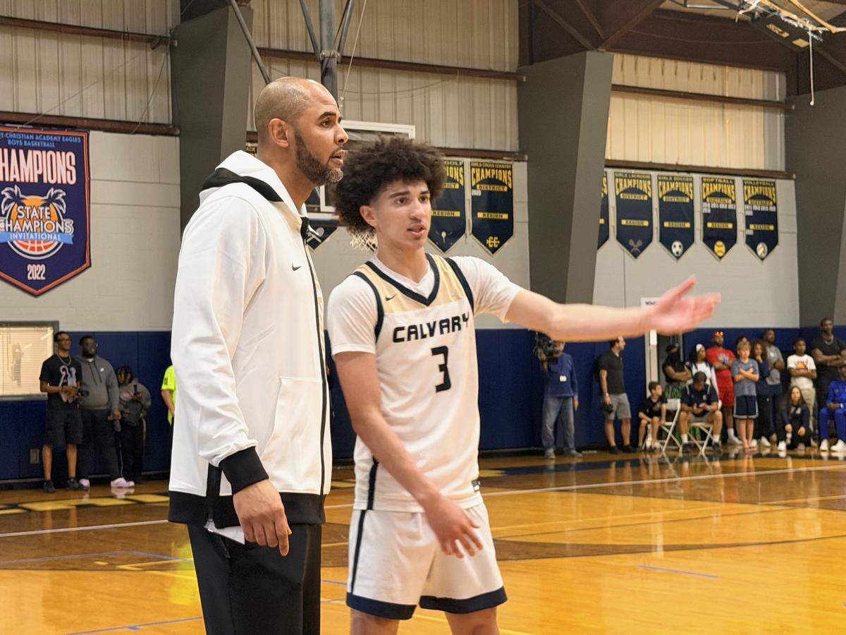 Calvary Christian’s Cayden Daughtry (right) talks to coach Cilk McSweeney during fourth quarter time out in Saturday’s Region 3-3A final at Calvary Christian.