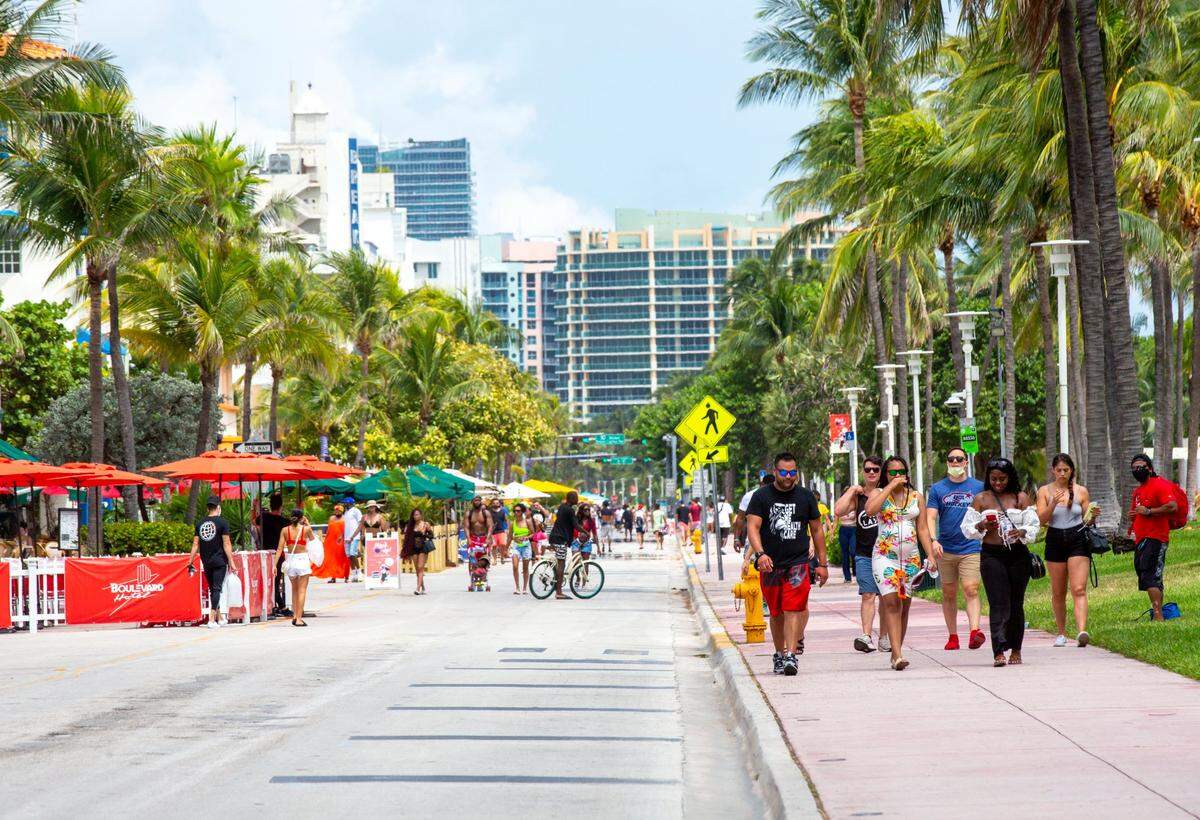 Masked and unmasked people walk down Ocean Drive during Labor Day weekend in Miami Beach on Saturday, September 5, 2020.