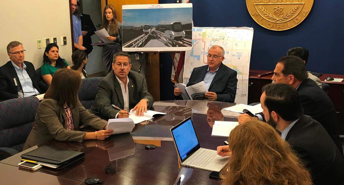 Miami-Dade Commissioner Jose "Pepe" Diaz, second from left at the table, and Commission Chairman Esteban "Steve" Bovo sit in front of a rendering of a proposed transit system for the American Dream Miami mega-mall in Northwest Miami-Dade. The meeting on Monday, May 14, was called by Commissioner Xavier Suarez days before a planned final vote on the project on May 17.