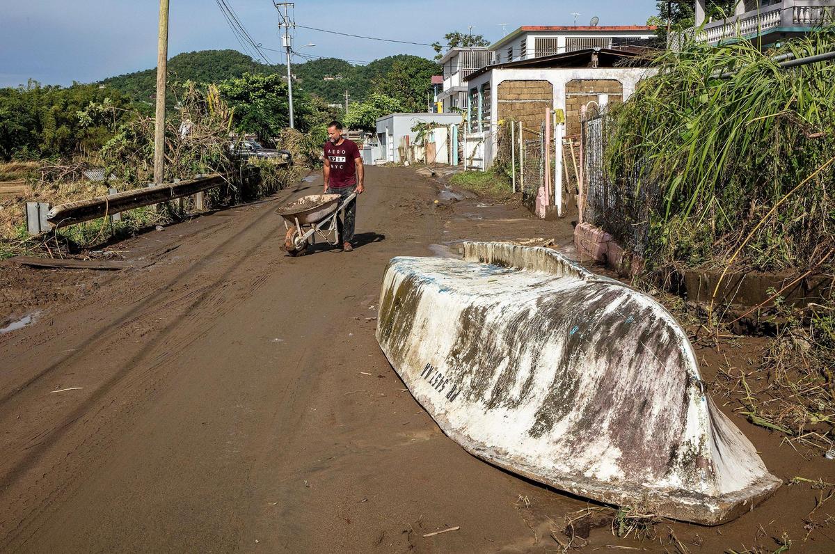 Samuel Santiago removes mud from the front of his house in the San Jose de Toa Baja neighborhood on Tuesday, September 20, 2022.