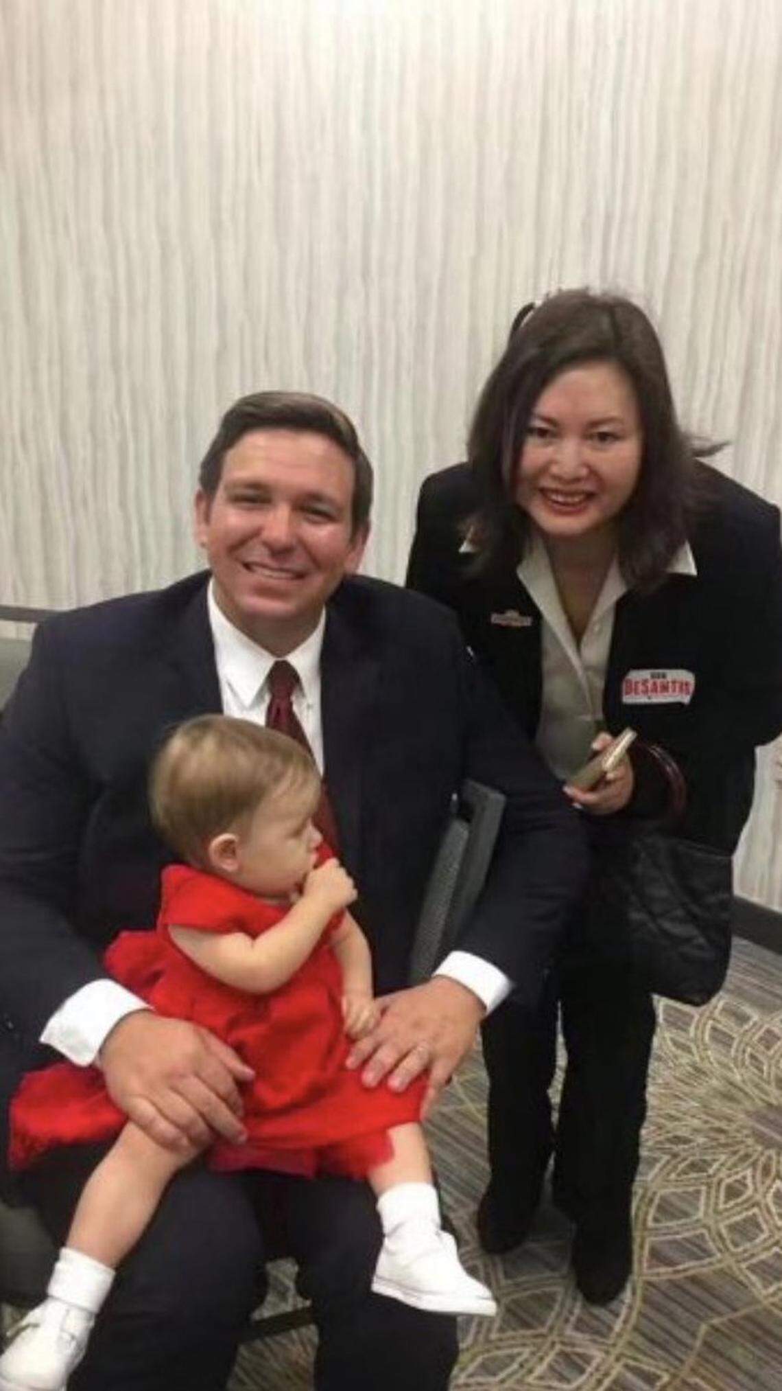 Now-Gov. Ron DeSantis, with his daughter, Madison, seated on his lap, poses for a picture with Li ‘Cindy’ Yang at the Embassy Suites by Hilton Boca Raton on Jan. 29, 2018, the day he launched his campaign.