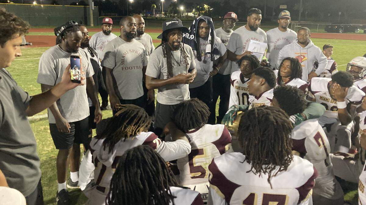 Miami Springs football coach T.Y. Hilton (middle) speaks to the Hawks’ players after they beat Pembroke Pines Flanagan last week in their spring football game.