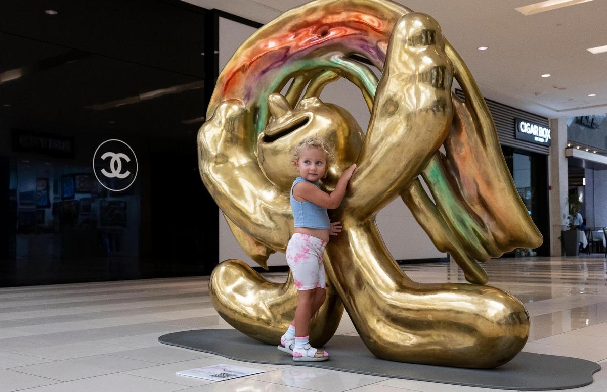 Adelina Logacheva, 3, interacts with ‘Joy,’ a sculpture by Austin Lee, one of the many art installations available for visitors to see at Aventura Mall on Wednesday, Sept. 25, 2024, in Aventura, Fla.