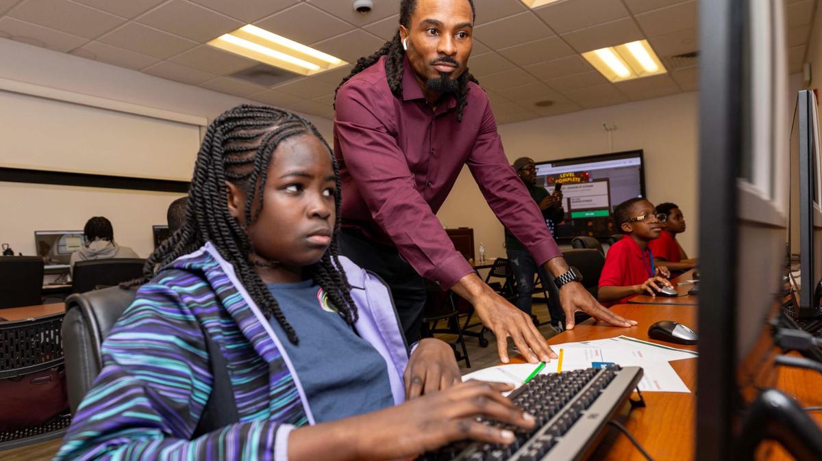Miami Gardens Director of Educational Development, Sherman Gant, assists Mylahna Paulk, 10, at a coding workshop sponsored by Miami Gardens’ Department of Educational Development.