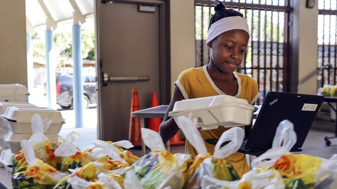 Shaniya Jacqueslouis picks up lunch at Toussaint L’Ouverture Elementary School, where 200 meals were served to students and family members between 9 a.m. and 12:30 p.m. Monday, March 16, during the first week of school closure due to the coronavirus. The school is in Miami’s Little Haiti neighborhood.
