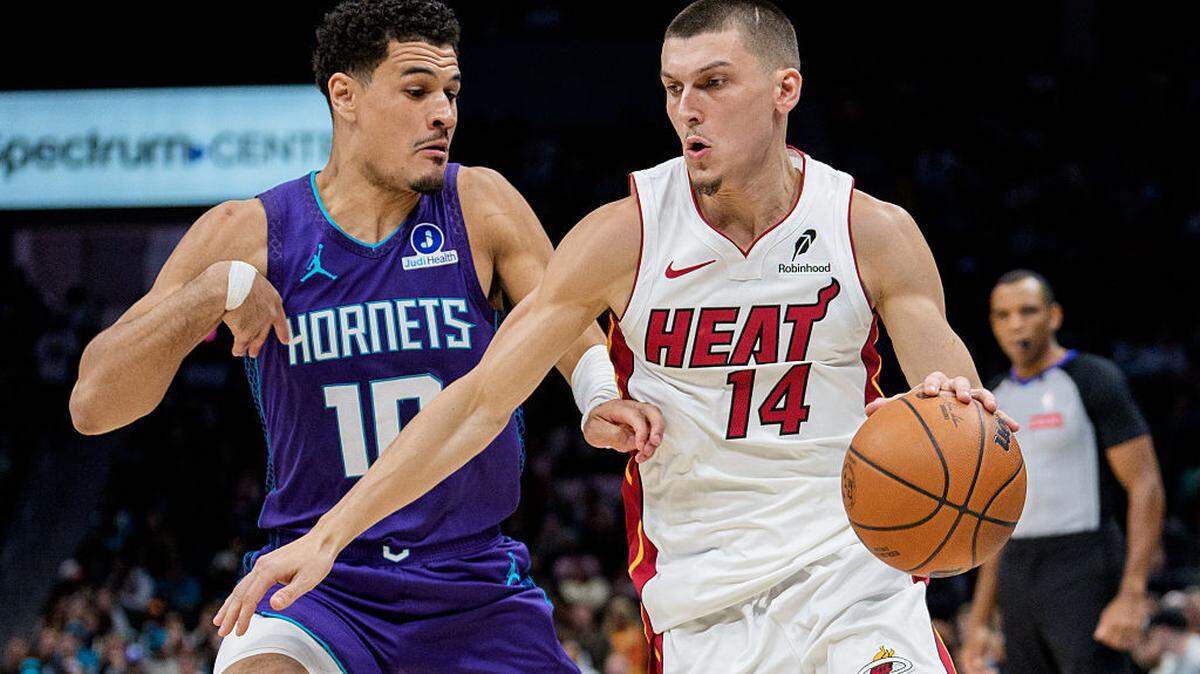 Tyler Herro #14 of the Miami Heat drives to the basket while guarded by Josh Green #10 of the Charlotte Hornets in the first half during their game at Spectrum Center on March 17, 2026 in Charlotte.