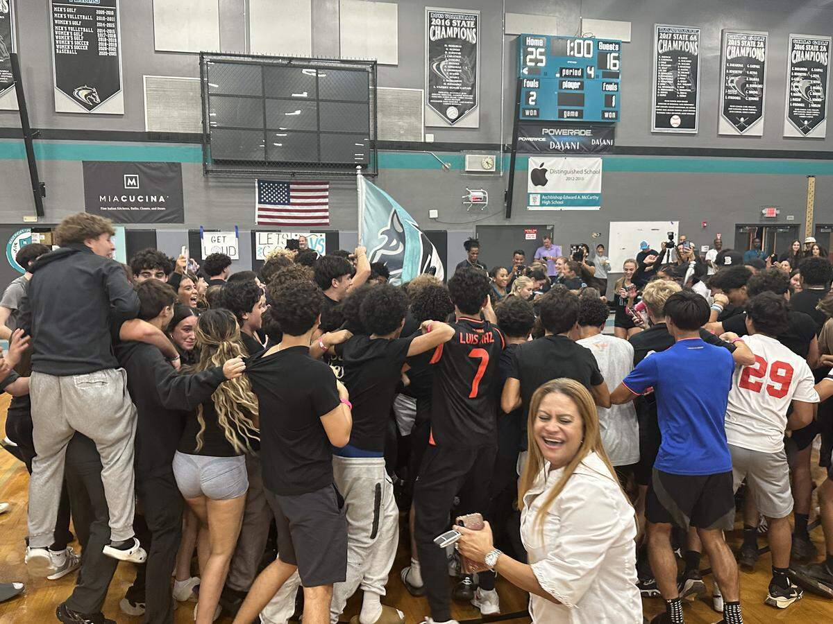 Archbishop McCarthy students and fans swarm the court after the Mavericks’ girls’ volleyball team beat Lourdes Academy on Wednesday night at McCarthy.