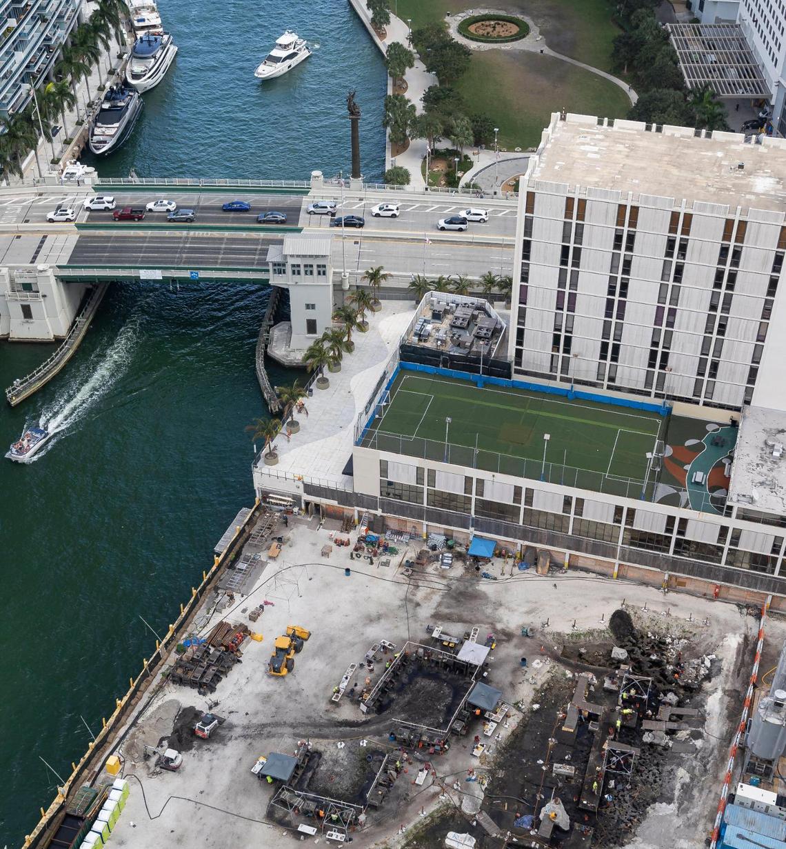 An aerial photograph from early 2023 shows the site of an active archaeological dig, at bottom, that uncovered remnants of a prehistoric indigenous village on the Miami River, before construction of two new residential towers got under way. Archaeologists believe the village extends below the 444 Brickell Ave. office building, at center, slated for eventual demolition and redevelopment by the Related Group. The Miami Circle National Historic Landmark, a 2,500-year-old portion of the larger ancient village that has been preserved as a park, is visible at top.