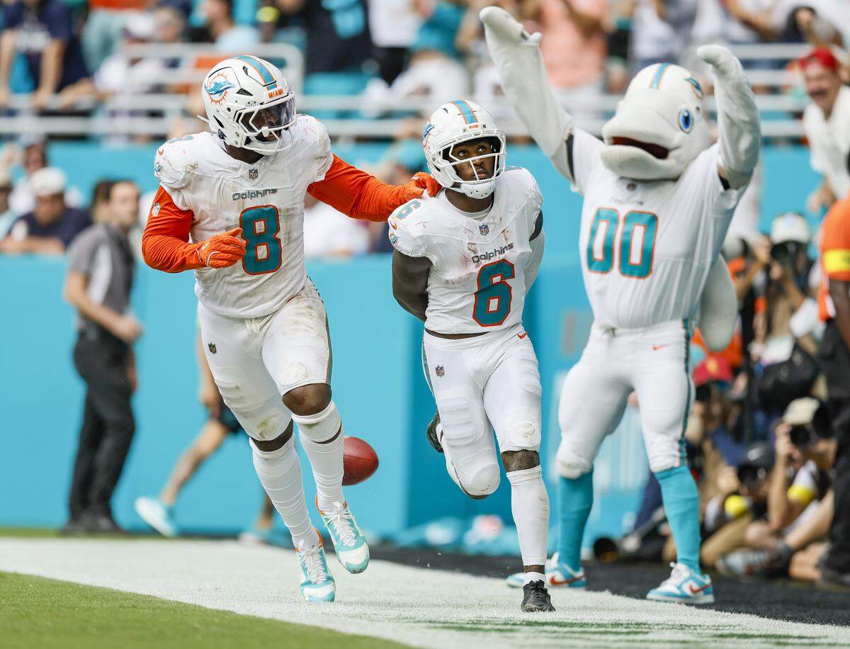 Miami Dolphins wide receiver Malik Washington (6) celebrates with running back Alexander Mattison (8) after Washington scores in the second half of an NFL football game against the New England Patriots at Hard Rock Stadium in Miami Gardens, Florida, on Sunday, September 14, 2025.