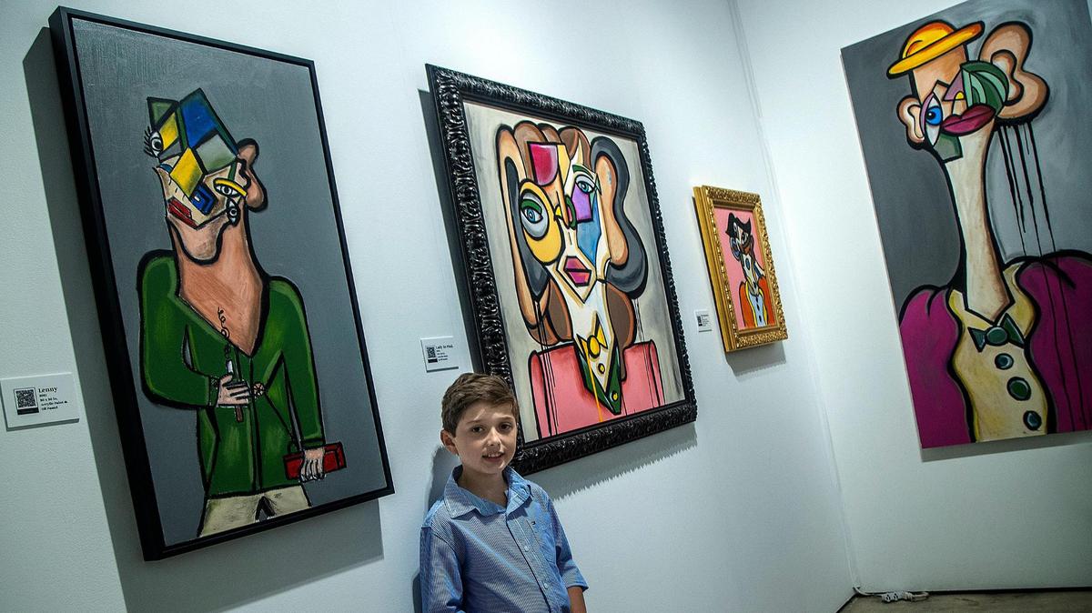 Andrés Valencia, de 10 años, con algunas de sus obras en su stand de Art Miami. El joven admirador de George Condo y Picasso pintará en vivo el sábado.