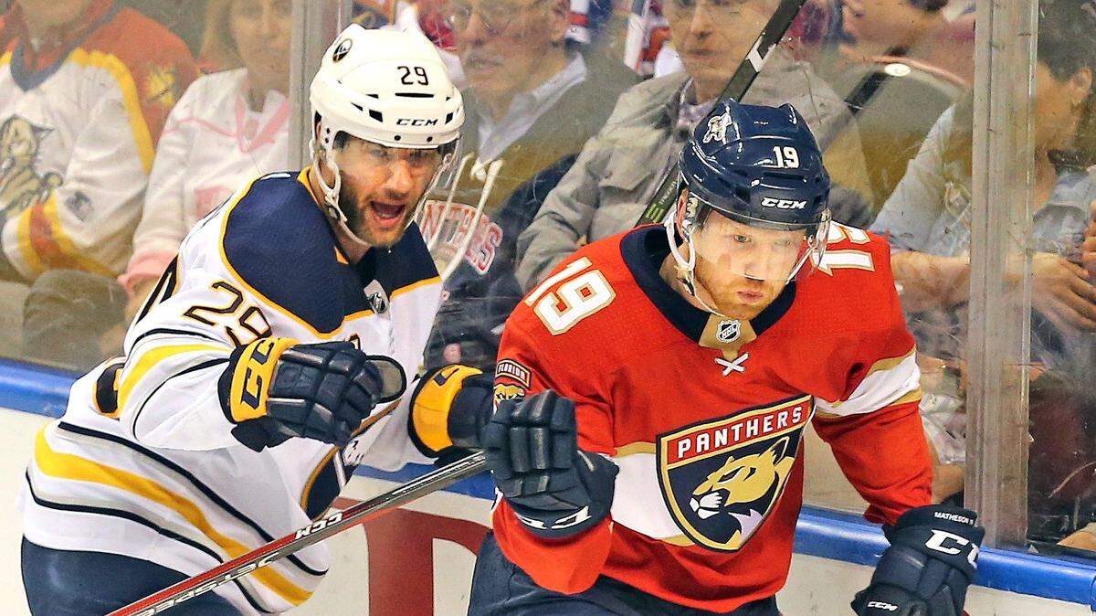 Florida Panthers Mike Matheson and Buffalo Sabres Jason Pominville move along the glass as they chase the puck in the first period at the BB&T Center in Sunrise, Florida, April 7, 2018. Florida Panthers players Ian McCoshen and Matheson get chance to return to Boston for the Comm Ave Charity Classic.