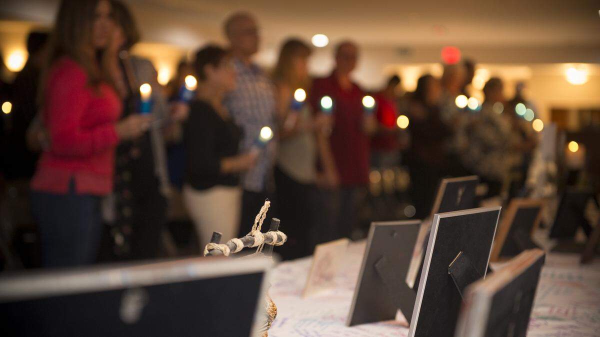 Bereaved family members and friends light remembrance candles to honor the memories of children who have died at a Miami Chapter of The Compassionate Friends event.