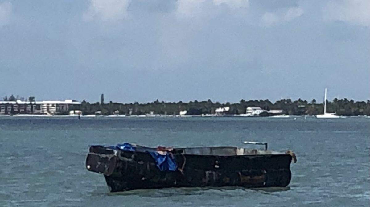 A migrant boat floats offshore of Windley Key in the Florida Keys Thursday, March 10, 2022. Border Patrol officials say 10 people arrived on the vessel from Cuba.