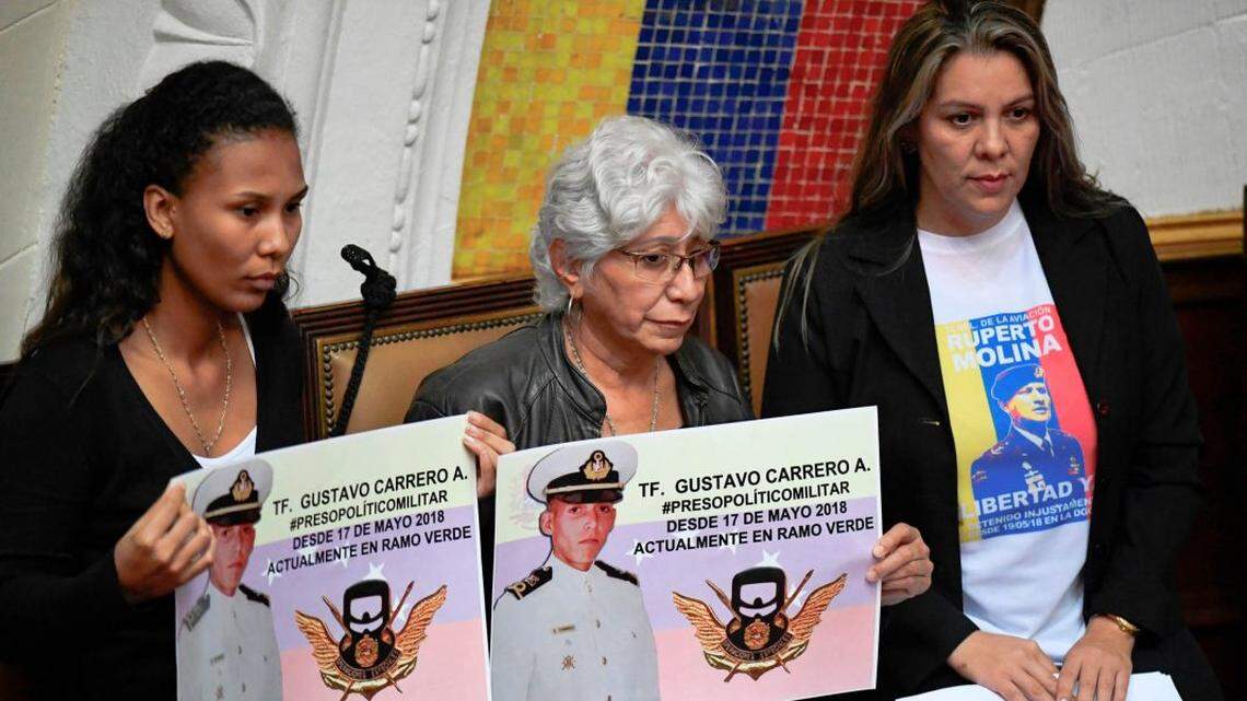 Relatives hold up images of a member of Venezuela’s military whom the Maduro regime arrested and imprisoned.
